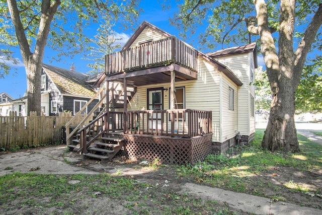 rear view of house featuring a wooden deck