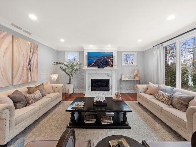 living room featuring crown molding, a fireplace, and a healthy amount of sunlight