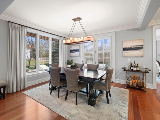 dining area featuring hardwood / wood-style flooring, ornamental molding, and plenty of natural light