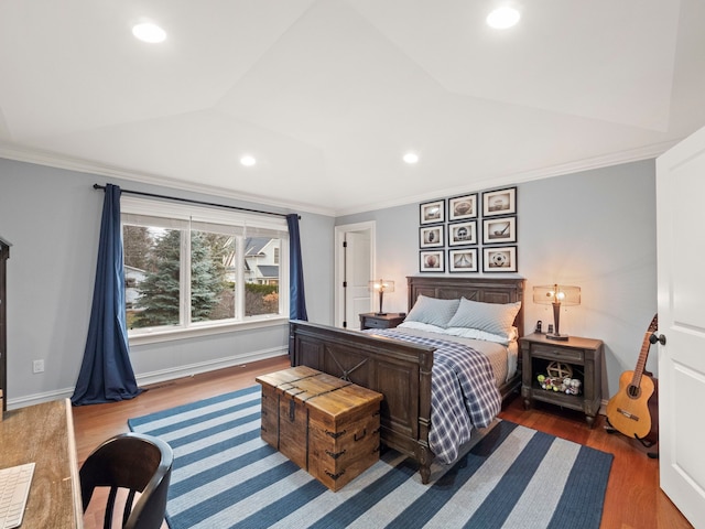 bedroom with crown molding, lofted ceiling, and wood-type flooring