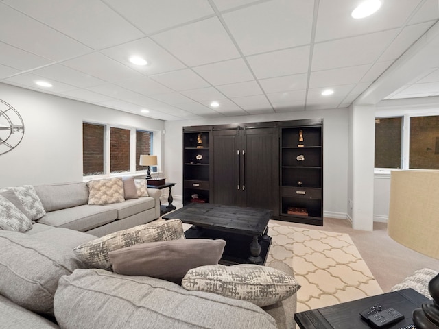 living room with a paneled ceiling and light carpet