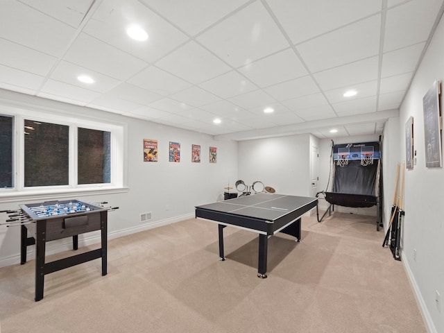 rec room with a paneled ceiling and light colored carpet