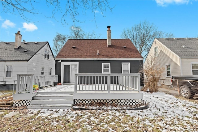 snow covered house with a wooden deck