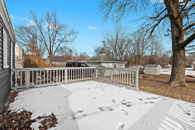 snow covered deck with a storage unit