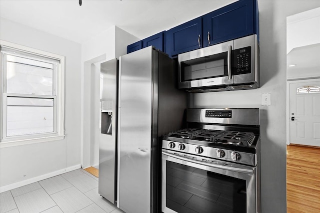 kitchen with stainless steel appliances, blue cabinets, and light wood-type flooring