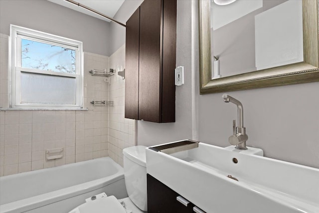 full bathroom featuring vanity, tiled shower / bath combo, and toilet