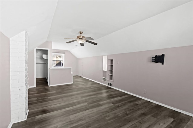 bonus room with lofted ceiling, built in shelves, dark wood-type flooring, and ceiling fan