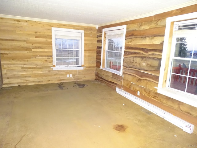 empty room with concrete flooring, ornamental molding, and wooden walls