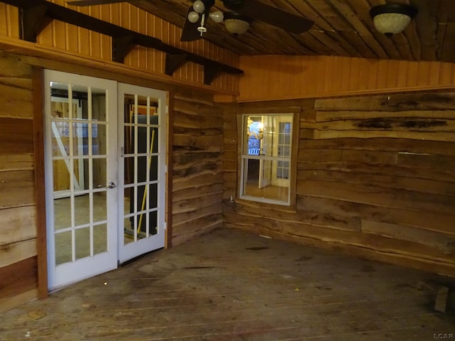 interior space with ceiling fan, wooden walls, french doors, and wood-type flooring