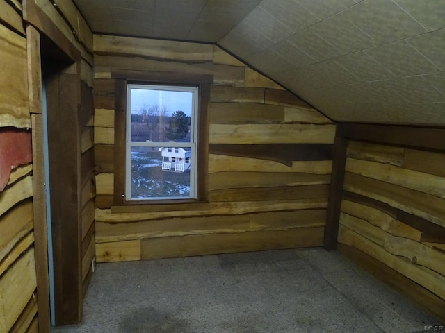 bonus room with vaulted ceiling, carpet, and wood walls