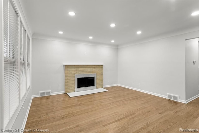 unfurnished living room with a fireplace and light hardwood / wood-style floors