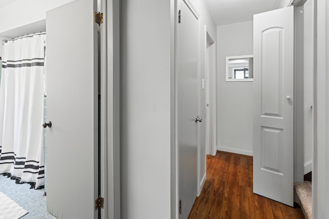 corridor with dark hardwood / wood-style flooring