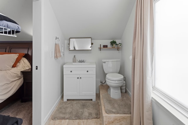 bathroom featuring vanity, lofted ceiling, a wealth of natural light, and toilet