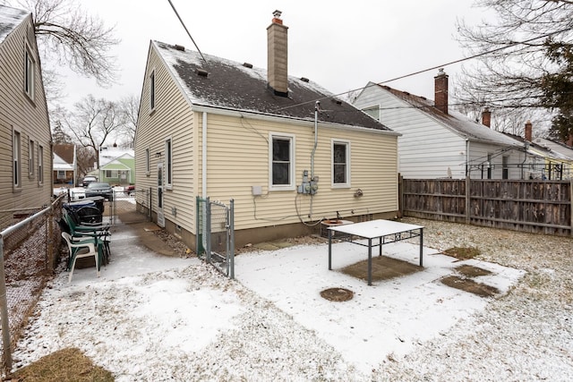 view of snow covered rear of property