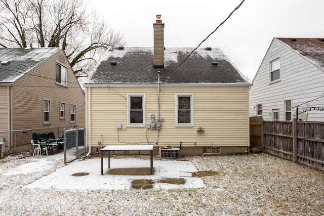 snow covered back of property featuring cooling unit