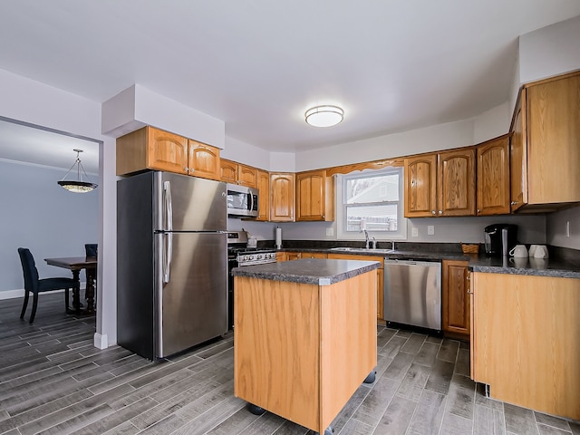 kitchen with stainless steel appliances, decorative light fixtures, a center island, and sink