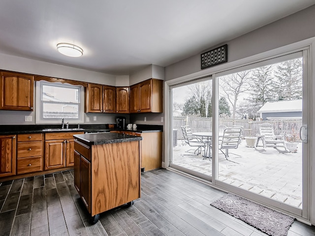 kitchen featuring a kitchen island, sink, dark hardwood / wood-style flooring, and plenty of natural light