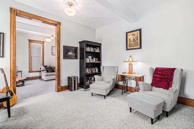 sitting room featuring carpet flooring and beam ceiling