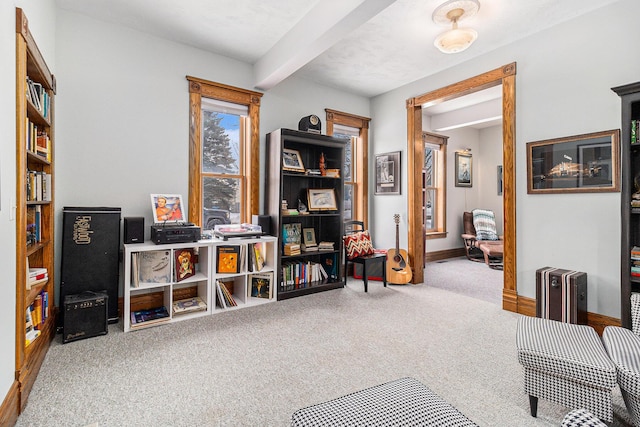 living area with beamed ceiling and carpet flooring