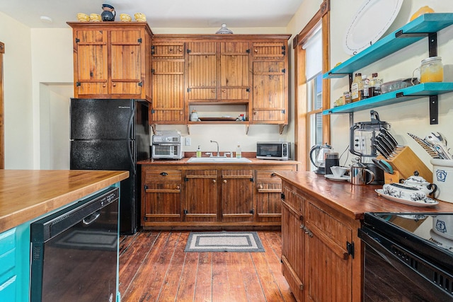 kitchen with sink, dark hardwood / wood-style floors, and black appliances