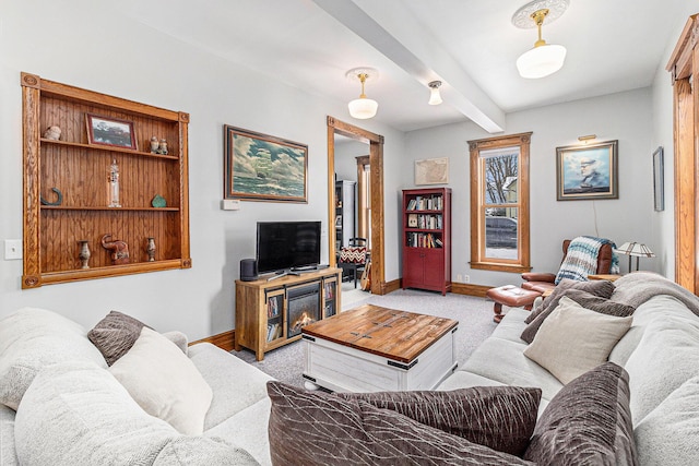 living room with beamed ceiling and light colored carpet