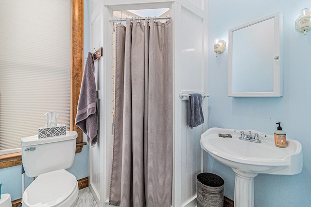 bathroom with toilet and a shower with shower curtain