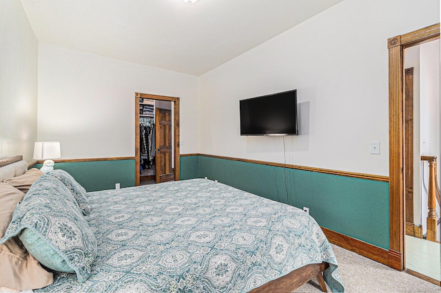 carpeted bedroom with a walk in closet and a closet