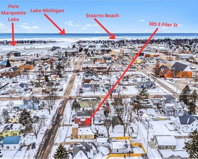 snowy aerial view featuring a water view