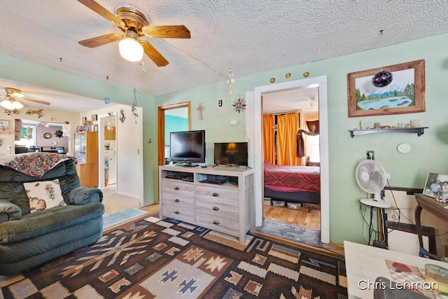 living room with ceiling fan and a textured ceiling