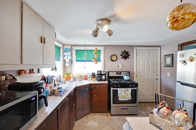 kitchen with dark brown cabinetry, stainless steel appliances, and sink