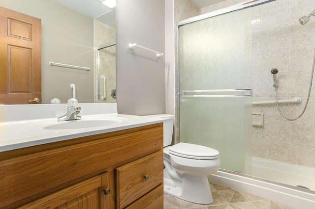 bathroom featuring vanity, tile patterned floors, a shower with door, and toilet