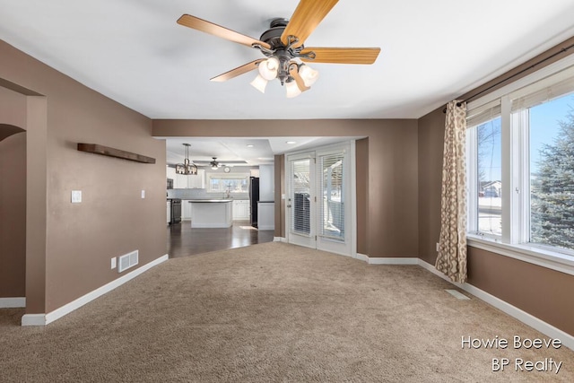 unfurnished living room with carpet flooring and ceiling fan