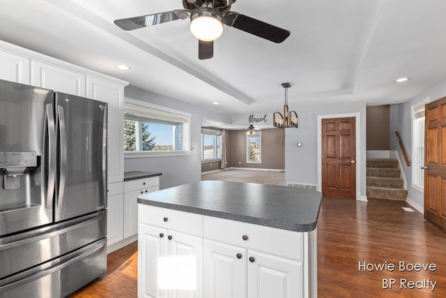 kitchen with ceiling fan, white cabinetry, a tray ceiling, dark hardwood / wood-style flooring, and stainless steel fridge with ice dispenser