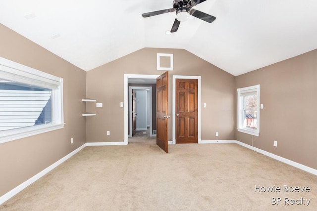 unfurnished bedroom with light carpet, vaulted ceiling, and ceiling fan