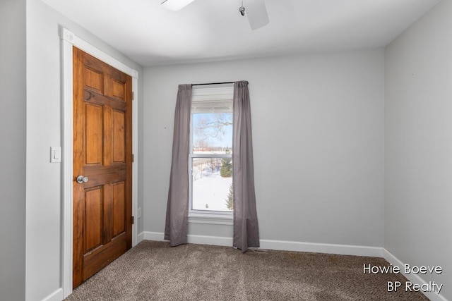 carpeted spare room featuring ceiling fan