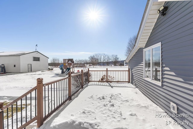 snow covered deck with a playground