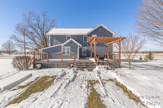 snow covered property featuring a wooden deck and a pergola