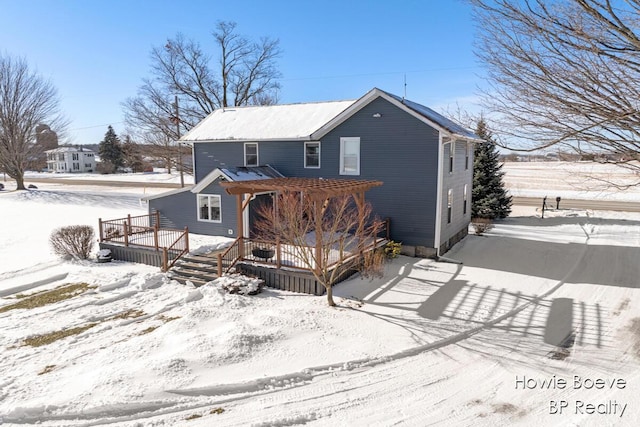 snow covered rear of property featuring a deck