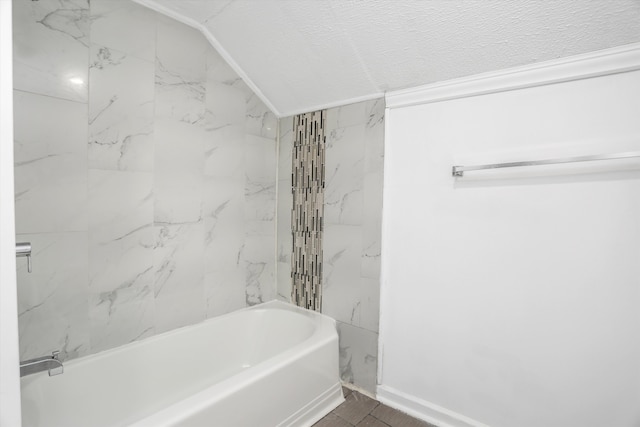 bathroom featuring tiled shower / bath and vaulted ceiling