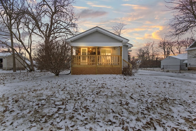 snow covered property with covered porch