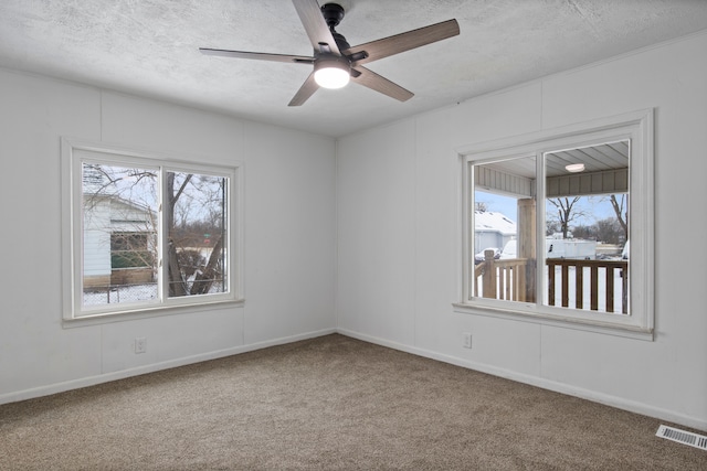 unfurnished room with ceiling fan, carpet floors, and a textured ceiling