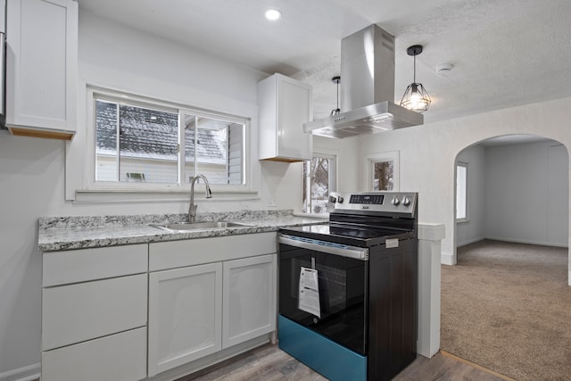 kitchen with white cabinetry, sink, island range hood, and stainless steel electric range oven