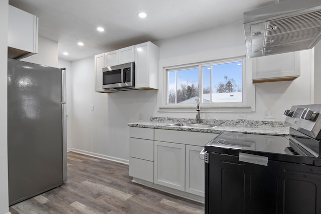 kitchen with white cabinetry, stainless steel appliances, light hardwood / wood-style floors, and sink