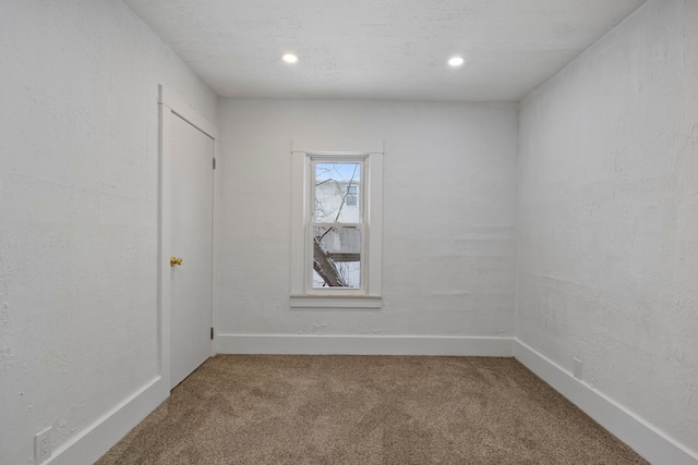 empty room with a textured ceiling and carpet