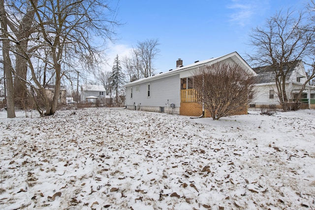 view of snow covered back of property