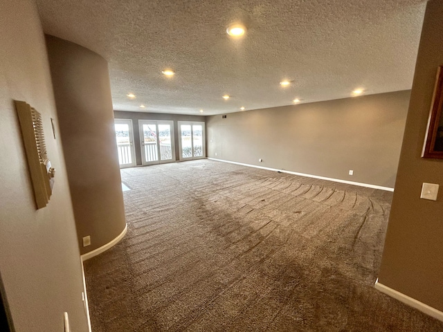 carpeted spare room featuring a textured ceiling