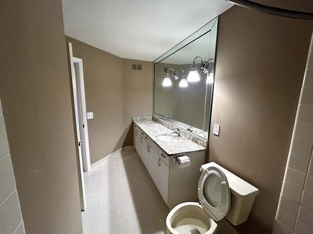 bathroom featuring vanity, tile patterned floors, and toilet