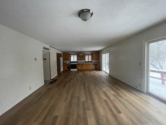 unfurnished living room featuring a textured ceiling and dark hardwood / wood-style flooring