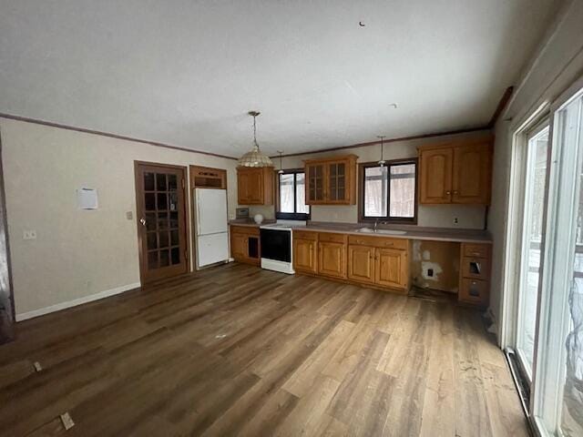 kitchen with pendant lighting, sink, crown molding, light hardwood / wood-style flooring, and white refrigerator