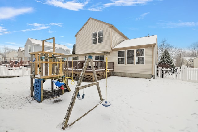 snow covered playground with a wooden deck